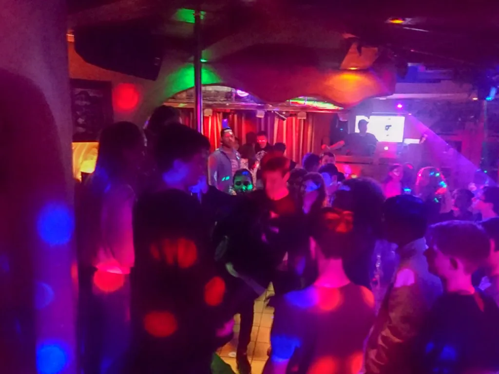 Volle Tanzfläche in buntem Licht.